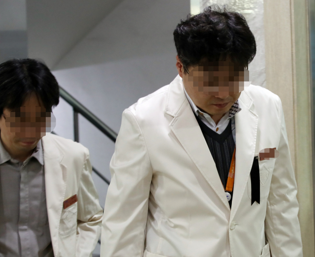 외래 진료환자가 휘두른 흉기에 숨진 고(故) 임세원 강북삼성병원 정신건강의학과 교수의 빈소가 2일 서울 종로구 새문안로 서울적십자병원 장례식장에 마련됐다. 조문을 마친 강북삼성병원 동료 의료진이 침통한 모습으로 장례식장을 나서고 있다. 왼쪽 가슴에 단 근조 리본이 보인다. 연합뉴스