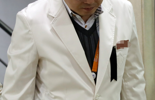 외래 진료환자가 휘두른 흉기에 숨진 고(故) 임세원 강북삼성병원 정신건강의학과 교수의 빈소가 2일 서울 종로구 새문안로 서울적십자병원 장례식장에 마련됐다. 조문을 마친 강북삼성병원 동료 의료진이 침통한 모습으로 장례식장을 나서고 있다. 왼쪽 가슴에 단 근조 리본이 보인다. 연합뉴스