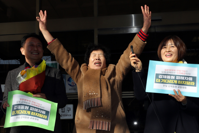 일본 미쓰비시중공업을 상대로 3차 손해배상 청구 소송을 제기한 일제 강제노역 피해자의 유족 이경자 씨(가운데)가 지난해 12월 14일 오후 광주 동구 지산동 광주지방법원 청사 앞에서 만세를 외치고 있다. 3차 소송 항소심 재판부는 1심에 이어 이날 미쓰비시의 배상 책임을 인정했다. 연합뉴스