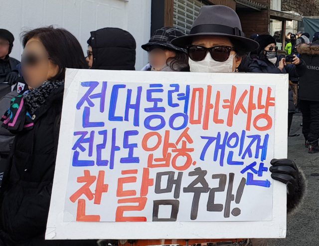 전두환 전 대통령을 지지하는 보수단체 회원들이 7일 서울 서대문구 연희동 전 대통령 자택 앞에서 집회를 열고 광주지법을 규탄하는 손팻말을 들어보이고 있다. 연합뉴스