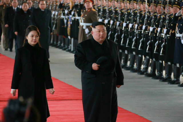 김정은 국무위원장이 리설주 여사와 함께 중국을 방문하기 위해 7일 오후 평양을 떠났다고 노동당 기관지 노동신문이 1면에 보도했다. 김 위원장은 시진핑(習近平) 중국 국가주석의 초청을 받았으며 이달 10일까지 중국에 머물 예정이라고 신문은 전했다. 사진은 김위원장이 리여사와 함께 걷고 있는 모습. [국내에서만 사용가능. 재배포 금지. For Use Only in the Republic of Korea. No Redistribution] 연합뉴스