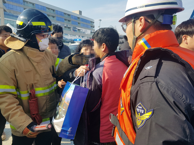 11일 오전 경남 통영 욕지도 해상에서 발생한 낚시어선 무적호 전복사고로 구조된 한 낚시객이 가족을 만나 외투를 건네받고 있다. 연합뉴스