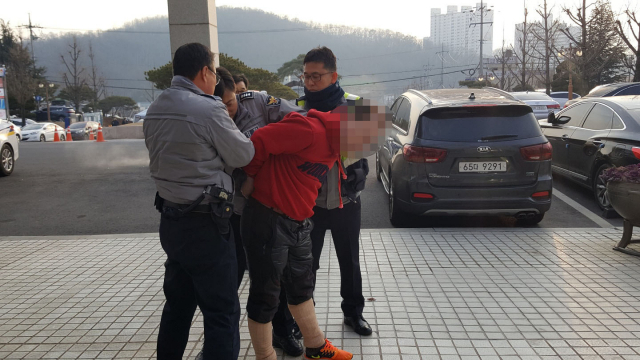 50대 남성이 11일 오전 김천시청에서 농성 중인 민주노총 노조원들을 향해 흉기를 휘두르며 난동을 부리다가 경찰에 붙잡히고 있다. 연합뉴스