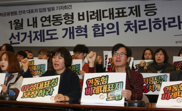 14일 오전 서울 중구 프레스센터에서 열린 정치개혁공동행동 전국 대표자 입장 발표 기자회견에서 참석자들이 선거개혁을 요구하는 손팻말을 들고 있다. 연합뉴스