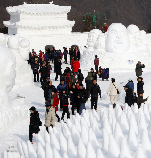 태백산 눈축제에서 눈조각을 감상하는 관광객들.