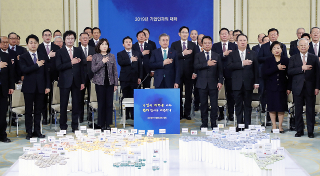 문재인 대통령이 15일 오후 청와대 영빈관에서 열린 2019년 기업인과의 대화에서 참석 기업인들과 함께 국기에 경례하고 있다. 연합뉴스