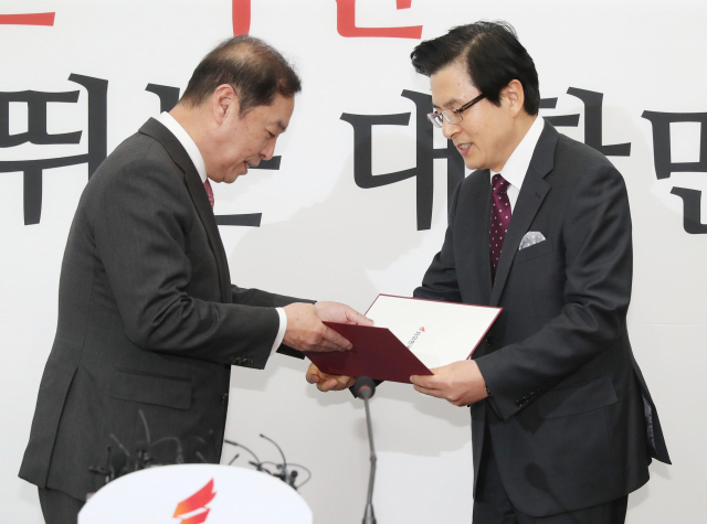 황교안 전 국무총리가 15일 오전 국회 본청 자유한국당 회의실에서 김병준 비대위원장에게 입당서를 제출하고 있다. 연합뉴스