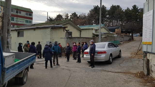 지난 10일 중단됐던 자동차정비공장 신축 공사를 재개하려 자재 반입을 시도하자 새방골 주민들이 이를 막아서고 있다. 독자 제공.