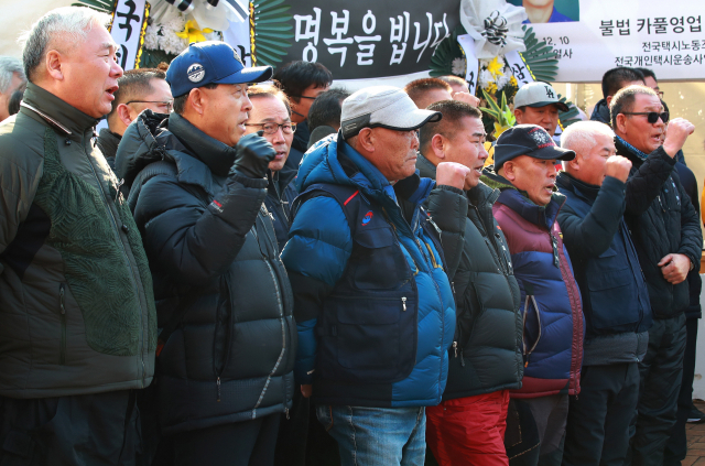 전국택시노동조합연맹, 전국개인택시운송사업조합연합회 등 택시 4개 단체 회원들이 18일 오후 서울 여의도 국회의사당역 인근에 마련된 택시기사 고(故) 임모 씨 분향소 앞에서 카풀 문제 해결을 위한 사회적 대타협기구 참여와 관련해 기자회견을 하며 구호를 외치고 있다. 연합뉴스