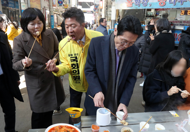 정의당 이정미(왼쪽)대표가 14일 노회찬 전 대표의 지역구였던 창원시 성산구 반송시장을 찾아 어묵을 먹고 있다. 왼쪽부터 이 대표, 여영국 4·3 창원성산 국회의원 보궐선거 정의당 후보, 윤소하 원내대표. 연합뉴스