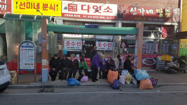 노인들이 버스승강장에 설치된 온열벤치에 앉아 있다. 거창군 제공