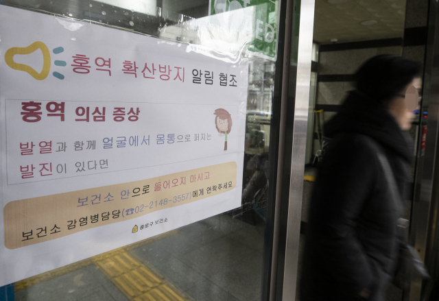 대구에 이어 경기도 안산 등지에서도 영유아가 홍역 확진 판정을 잇따라 받으면서 위생관리에 비상이 걸린 21일 오후 서울 종로구보건소 입구에 홍역 확산방지 관련 협조문이 붙어 있다. 연합뉴스