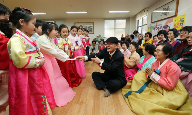 설 연휴를 일주일 앞둔 28일 서울 송파구 엘스 아파트 노인정에서 지역 어린이집 원생들이 어르신들께 세배로 새해 인사를 하고 세뱃돈을 받고 있다. 연합뉴스