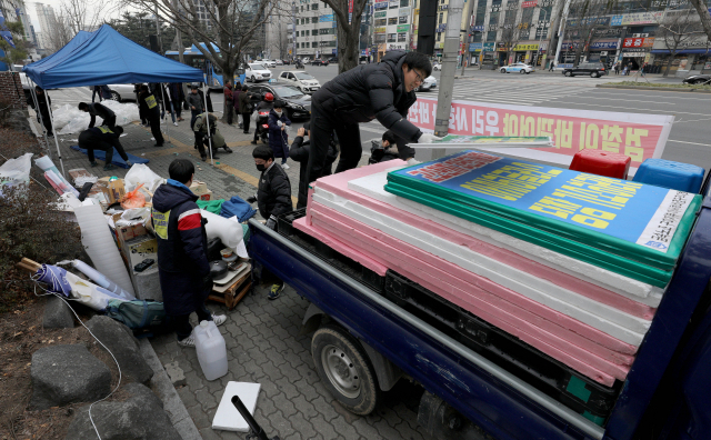 대검찰청 검찰수사심의위원회가 아사히글라스와 원청업체를 불법 파견 혐의 등으로 기소해야 한다는 의견을 내자 금속노조 아사히비정규직지회 노조원들이 14일 대구지방검찰청 앞에서 벌이던 농성을 풀고 천막을 철거하고 있다. 김영진 기자 kyjmaeil@imaeil.com