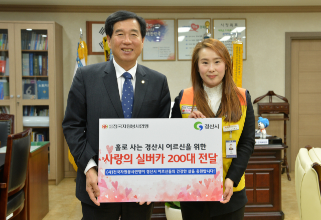(사)전국자원봉사연맹 이현미 기획부장(오른쪽)이 14일 최영조 경산시장에게 거동이 불편해 외출이 어려운 어르신들의 이동 편의를 돕기 위한 보행 보조기 200대를 기탁했다. 경산시 제공