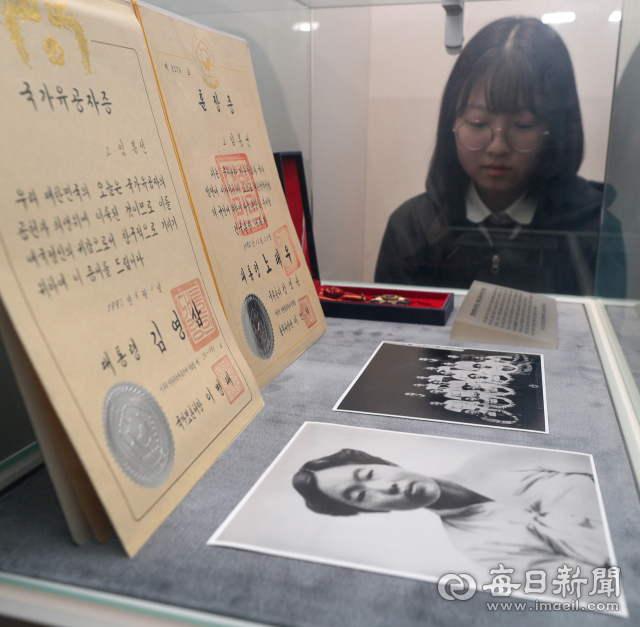 성화여고 CTW 동아리 학생이 신명역사관에 전시된 임봉선의 사진과 훈장증을 바라보는 모습. 성일권 기자 sungig@imaeil.com