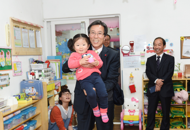 문경시는 전국 자치단체 중 처음으로 인재양성과 인구증가효과를 동시에 거둘 수 있는 파격적인 다자녀 특별장학금지원을 결정했다. 고윤환 문경시장이 지역 내 어린이시설을 방문해 한 어린이를 안고 환하게 웃고 있다. 문경시 제공