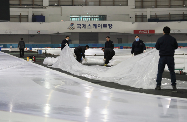 제100회 전국동계체육대회 스피드스케이팅 경기가 예정된 20일 오후 서울 노원구 태릉국제스케이트장에서 관계자들이 천장 누수로 인해 덮어뒀던 비닐을 걷어내고 있다. 이날 오전 11시부터 열리기로 한 경기는 오후 5시로 연기됐다. 연합뉴스