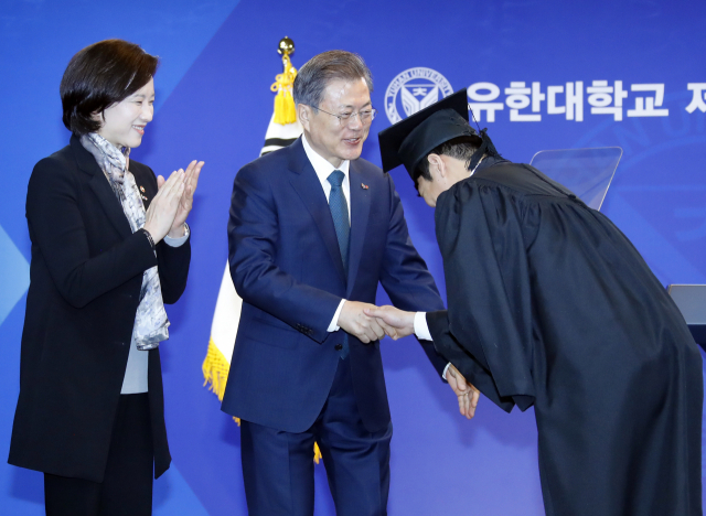 문재인 대통령이 21일 오전 경기도 부천시 유한대학교에서 열린 졸업식에서 유은혜 사회부총리 겸 교육부 장관과 함께 수상한 졸업생들과 악수를 하며 격려하고 있다. 유한대학교는 독립운동가이자 기업인, 교육자로 한평생 국민과 국가를 위해 봉사한 유일한 박사가 설립한 학교로 현재 고등직업교육 기관으로 높은 평가를 받는 대학이다. 연합뉴스