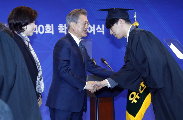 문재인 대통령이 21일 오전 경기도 부천시 유한대학교에서 열린 졸업식에서 유은혜 사회부총리 겸 교육부 장관과 함께 수상한 졸업생들과 악수를 하며 격려하고 있다. 유한대학교는 독립운동가이자 기업인, 교육자로 한평생 국민과 국가를 위해 봉사한 유일한 박사가 설립한 학교로 현재 고등직업교육 기관으로 높은 평가를 받는 대학이다. 연합뉴스