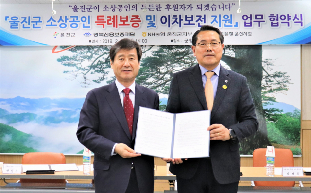 박진우(왼쪽) 경북신용보증재단 이사장과 전찬걸 울진군수가 소상공인 특례보증 지원을 위한 업무협약을 체결하고 있다. 경북신용보증재단 제공