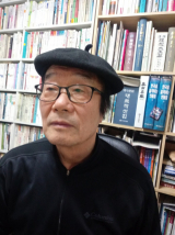 자신의 서재에서 책을 찾고 있는 송일호 작가.