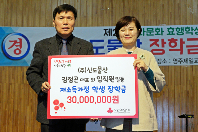 김점곤(왼쪽) 대표가 장학금을 전달하며 신혜영 경북사회복지공동모금회 사무처장과 기념사진을 찍고 있다. 경북사회복지공동모금회 제공