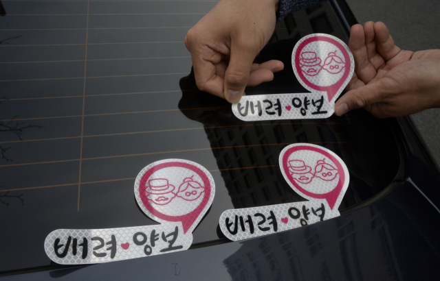 도로교통안전공단에서 실시하는 고령운전자 교육을 받은 노인이 자신의 차량에 배려와 양보를 나타내는 스티커를 붙이고 있다.이채근 기자 mincho@imaeil.cm
