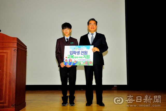 이종호 한수원 한울원자력본부장이 울진중학교 입학식에서 학생 대표에게 신입생 전원 교복 무상 지원서를 전달하고 있다. 한수원 제공