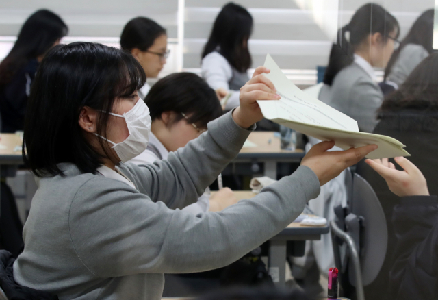 7일 오전 서울 동작구 수도여자고등학교에서 열린 올해 첫 전국연합학력평가에서 3학년 학생들이 시험지를 받고 있다. 연합뉴스