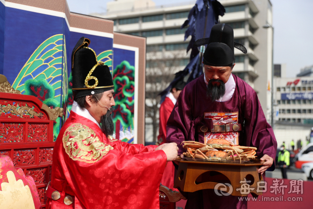 이희진 영덕군수가 9일 서울 광화문 광장에서 열린 대게 진상 퍼포먼스에서 신하(오른쪽)로 분장해 왕에게 영덕대게를 진상하고 있다. 영덕군 제공