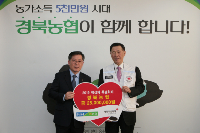 도기윤 경북농협 본부장이 강보영 대한적십자사 경북지사 회장에게 적십자 특별회비를 전달하며 기념사진을 찍고 있다. 경북농협 제공