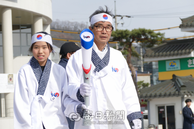 손병선 광복회 안동시지부장과 학생이 대구에서 온 횃불을 맞이해 점화대로 이동하고 있다. 김영진 기자