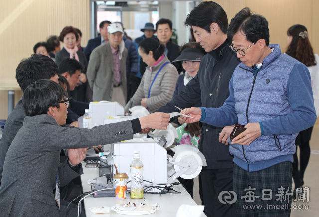 제2회 전국동시조합장선거일인 13일 대구 달성군 화원읍 화원농협에 마련된 투표소에서 조합원들이 투표용지를 받고 있다. 성일권 기자 sungig@imaeil.com