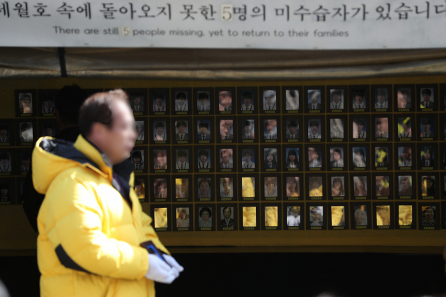 17일 서울 광화문광장 세월호 천막에서 열린 이안식에서 4·16 세월호 참사 유족들이 희생자 영정을 옮기고 있다. 세월호 천막은 2014년 7월 처음 설치된 후 약 4년 8개월 만에 유가족 측의 자진철거 의사에 따라 18일 모두 철거될 예정이다. 연합뉴스 #세월호 천막 #세월호 영정 #분향소