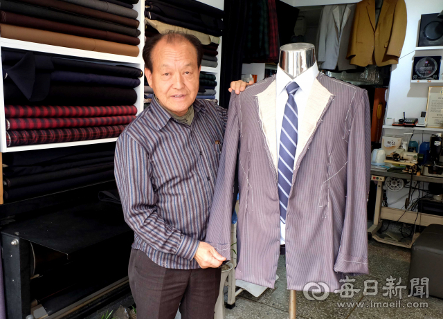 가봉한 양복 앞에 선 이경락 대표.