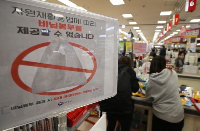 서울시는 4월 1일부터 일회용 비닐봉투를 사용한 대형마트, 슈퍼마켓 등에 최고 300만원의 과태료를 부과한다고 밝혔다. 올해 1월 자원재활용법 시행규칙 개정에 따라 3월 말까지 계도 기간을 거쳐 경고 없이 과태료를 부과할 방침이다. 적용 대상은 시내 대규모 점포 295곳, 매장 크기 165㎡ 이상 슈퍼마켓 1천555곳, 제과점 3천829곳이다. 사진은 28일 서울의 한 대형마트 계산대의 관련 안내문. 연합뉴스