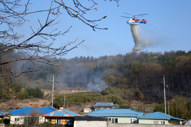 4일 오전 경북 포항시 남구 대송면 운제산 자락에서 헬기가 산불을 끄고 있다. 이곳에서는 3일 오후 7시 52분께 불이 나 포항시와 소방당국이 밤새 진화했다. 연합뉴스 #포항 산불