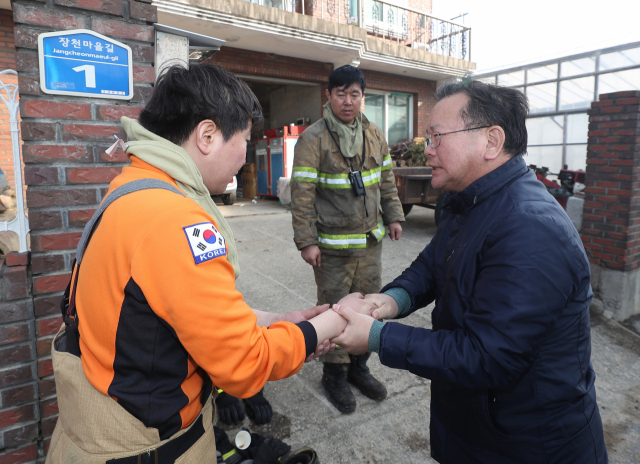 김부겸 행정안전부 장관이 5일 오전 전날 강원도 고성군 토성면에서 시작된 산불이 번진 속초시 장천마을을 찾아 화재진압 작전을 펼친 뒤 잠시 휴식을 취하는 소방대원들을 격려하고 있다. 연합뉴스