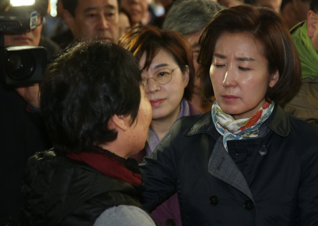 24일 경북 포항시 북구 흥해읍에 있는 흥해실내체육관에서 자유한국당 나경원 원내대표(오른쪽)가 지진 피해 이재민을 위로하던 중 한동안 눈을 감고 있다. 흥해실내체육관은 2017년 11월 15일 포항에서 일어난 지진으로 피해를 본 일부 이재민 임시구호소로 사용되고 있다. 연합뉴스