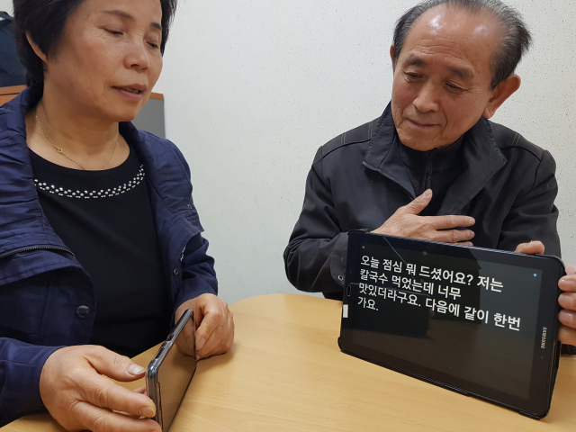 오만환(오른쪽)씨가 인공지능 앱을 활용해 음성을 인식을 바로 문자로 전환하는 것을 시연해 보이고 있다.