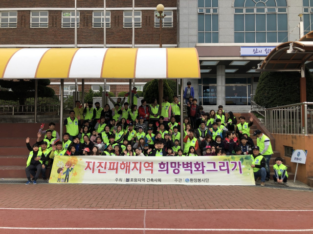 지난 7일 환장봉사단 회원 자녀들이 포항 북구 흥해읍 남산초등학교 벽화그리기 봉사활동을 마친 뒤 기념촬영을 했다. 환장봉사단 제공.