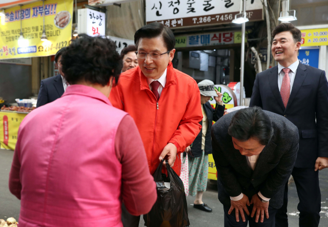 자유한국당 황교안 대표와 강기윤 당시 4·3 보궐선거 후보가 8일 오후 경남 창원시 성산구 반송시장을 찾아 상인에게 인사하고 있다. 연합뉴스