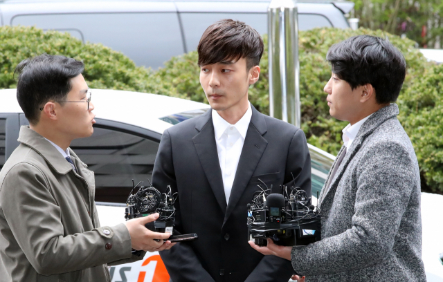 음란물 유포 혐의를 받는 가수 로이킴이 피의자 신분으로 조사를 받기 위해 10일 오후 서울지방경찰청으로 들어서고 있다. 연합뉴스