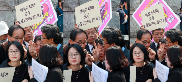 낙태죄폐지반대국민행동 단체 회원들이 11일 오후 서울 종로구 재동 헌법재판소 앞에서 헌법불합치 선고 결정을 확인하고 있다. 이날 헌재는 낙태한 여성을 처벌하는 형법 제269조 1항과 낙태 수술을 한 의사를 처벌하는 형법 제270조 1항이 재판관 4명, 3명(단순 위헌), 2명(합헌) 의견으로 헌법불합치라고 결정했다고 선고했다. 연합뉴스