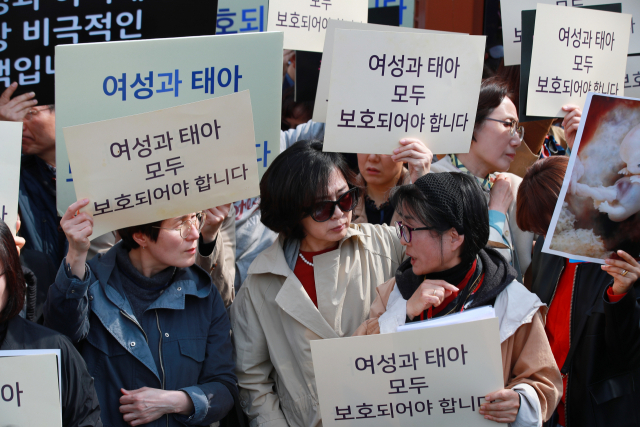 낙태죄폐지반대국민행동 단체 회원들이 11일 오후 서울 종로구 재동 헌법재판소 앞에서 판결 상황을 확인하고 있다. 연합뉴스