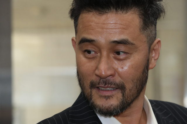 보복운전을 한 혐의로 재판에 넘겨진 배우 최민수 씨가 12일 오전 서울 양천구 서울 남부지법에서 열린 첫 공판에 출석하기 위해 법정으로 향하며 취재진의 질문을 듣고 있다. 연합뉴스