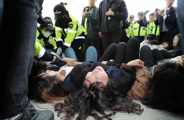12일 오전 자유한국당 나경원 원내대표의 국회 의원회관 사무실을 기습 점거했던 한국대학생진보연합 학생들이 회관 본청 현관 앞에서 농성을 이어가다 경찰에 연행되고 있다. 이들은 