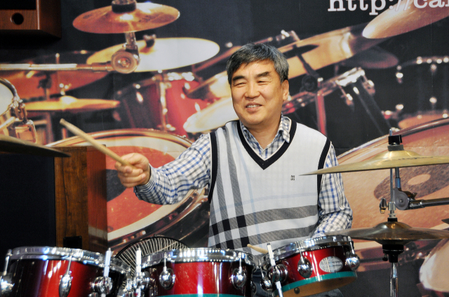 북을 두드리고 심벌즈를 치며 즐거워하고 있는 채원철 씨. 최재수 기자