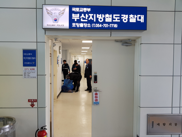 포항북부경찰서 경찰관들이 16일 오후 KTX 포항역에서 열차 폭발 소동을 벌인 A(61) 씨를 붙잡은 뒤 소지품을 확인하고 있다. 배형욱 기자
